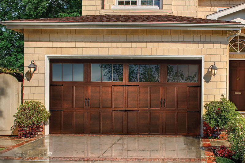 Wooden garage doors on a yellow house.