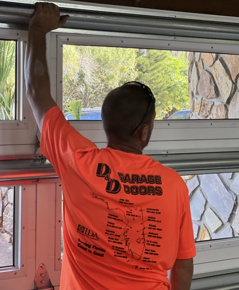 Technician installing a sleek, modern garage door at a residential property.