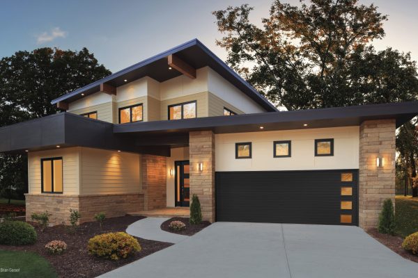 Modern house with a steel grooved black scaled garage door.